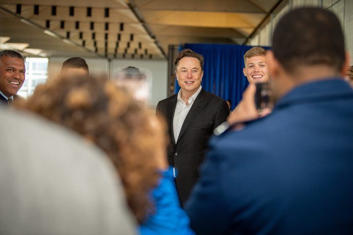 Elon Musk smiling and engaging with crowd at public event